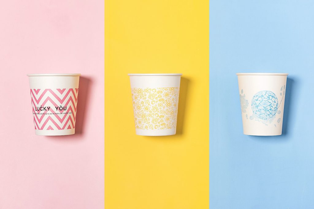 three different colored cups with designs on them